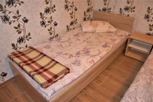 a small bedroom with a bed with floral wallpaper at Bungalows Dani in Kamchia