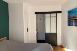 a bedroom with a bed and a sliding glass door at Le clos du Mesnil, Logement totalement indépendant in Le Tourne