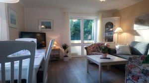 a small living room with a couch and a table at Bungalow in Tinnum