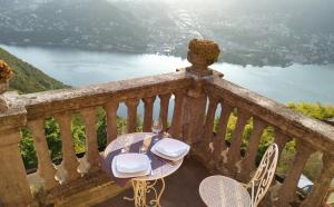 a table and chairs on a balcony with a view of a lake at B&B Il Balcone sul Lago in Brunate