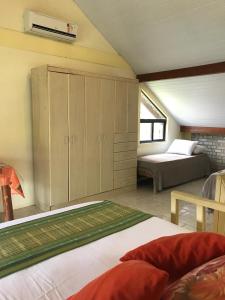 a bedroom with a bed and a bed and a window at Pousada Beija-Flor in Bombinhas