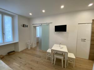 a room with a table and a tv on the wall at Antico Palazzo Lago Maggiore in Verbania