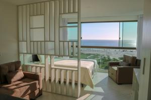 1 dormitorio con cama y vistas al océano en Sophia II Residence Inn, en Arraial do Cabo
