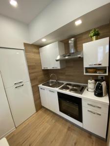 a kitchen with white cabinets and a stove top oven at Antico Palazzo Lago Maggiore in Verbania