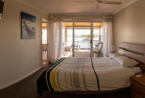 a bedroom with a bed and a view of the water at Waterside Canal Dreams in Mandurah