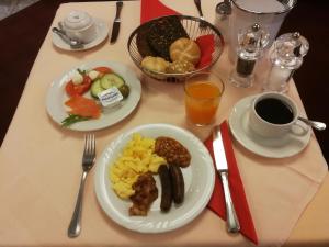 een tafel met borden ontbijtproducten en een kopje koffie bij Hotel An der Philharmonie in Keulen