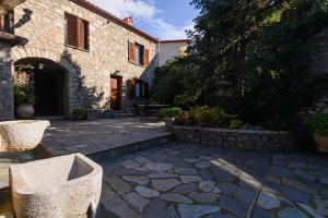 a stone patio in front of a building at Guesthouse Karahalios in Polydrossos +25 photos