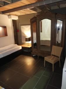 a bedroom with a bed and a chair and a mirror at Nuvola Loft in Zottegem +11 photos