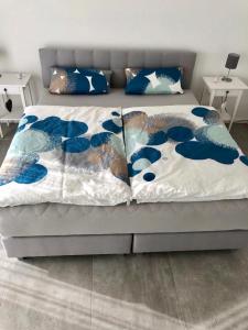 a bed with blue and white sheets and pillows at Ferienwohnung Landskroner Blick in Bad Neuenahr-Ahrweiler