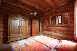 a bedroom of a log cabin with a bed and a cabinet at Usedlost Gerstein in Zálesí