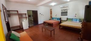 a living room with a couch and a table at Pousada Casa da Edinha in Ilha de Boipeba