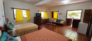Sala de estar con 2 camas y TV en Pousada Casa da Edinha en Ilha de Boipeba
