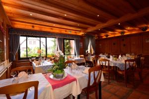 une salle à manger avec des tables et des chaises blanches dans l'établissement Au Soleil, Hôtel Restaurant & Spa, à Valff