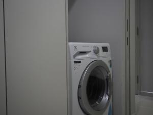 uma máquina de lavar roupa num quarto ao lado de uma porta em Serini Melawati em Kuala Lumpur