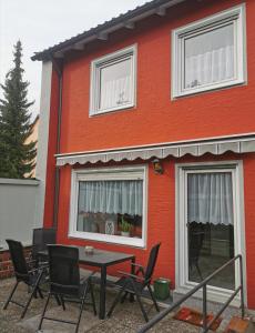 una mesa y sillas frente a una casa roja en Ferienhaus CasaNoWa en Kaufbeuren