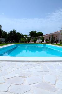 - une piscine d'eau bleue dans la cour dans l'établissement Villa lilly, à Leporano