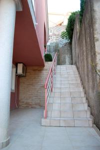 a staircase with a red railing next to a building at Omega Apartments in Ulcinj