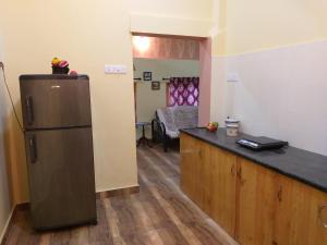 a kitchen with a counter and a refrigerator in a room at THE ENCHANTING NEST in Borim