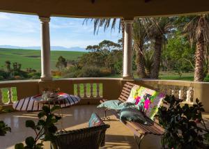 a porch with two chairs and a table with a view at Anna's Farm Stay in Slangrivier