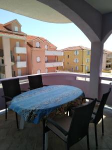 una mesa y sillas en un balcón con vistas en Apartments Teami, en Povljana