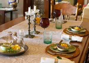 a table with plates of food and glasses of wine at Anna's Farm Stay in Slangrivier