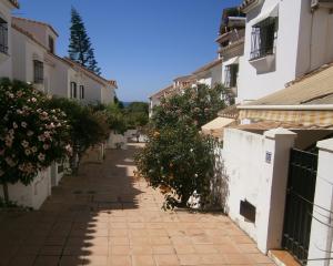 un callejón en una ciudad con algunos edificios en Casa Adelfas, Benajarafe, en Benajarafe