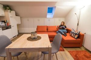 a woman sitting on a couch in a living room at Appartement Christiane in Bludenz