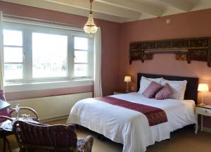 a bedroom with a large bed and two windows at B&B de Pastory in Warns