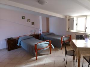 two beds in a room with a table and chairs at B&B Mansarda in Caserta