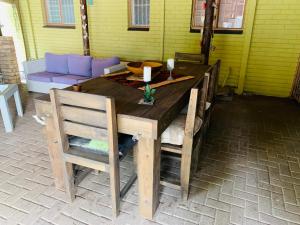 Una mesa y sillas de madera en un patio. en La Bohéme Gastehuis, en Bloemfontein 19 fotos más