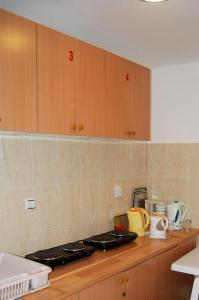 encimera de cocina con fogones y armarios de madera. en Omega Apartments, en Ulcinj