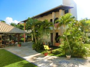 a house with a courtyard with palm trees in front of it at Casa-Vento Private Guest House in Cumbuco