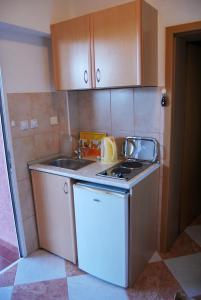 a small kitchen with a sink and a stove at Omega Apartments in Ulcinj