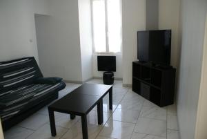 a living room with a couch and a tv at Paranthese à Marennes in Marennes