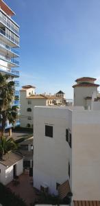a white building with a view of some buildings at ÁTICO TRIPLEX ISLA VERDE in El Campello