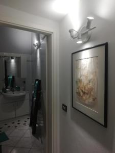 un baño con una pintura en la pared y un lavabo en DonnaBarbara, en Vernazza