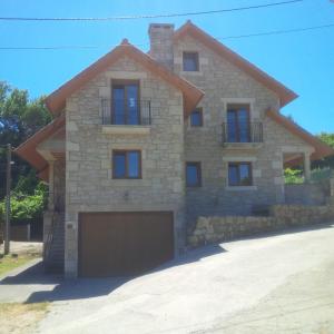 a large stone house with a garage at Chalet ENTERO CONFORT in Ribeira