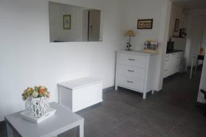 um quarto com mobiliário branco e uma cómoda branca em L'Oseraie em Moisenay