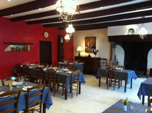 a dining room with blue tables and chairs and red walls at Chambres d'hôtes du puy d'anché in Sauzé-Vaussais