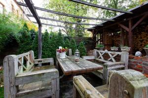 een houten tafel en banken in de tuin bij Ferienwohnung am Auensee in Leipzig