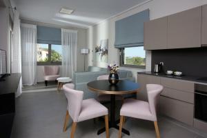 een keuken en een woonkamer met een tafel en stoelen bij Lagouvardos Village Hotel in Marathopolis