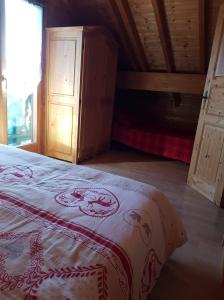 Chalet le Grizzly في لو ثولي: غرفة نوم بسرير وسقف خشبي