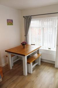 einen Holztisch in einem Zimmer mit Fenster in der Unterkunft Ladybird Cottage, Dog Friendly, Couples or Small families, Yorkshire Wolds - Countryside and Coast in Great Driffield