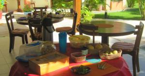 Casa-Vento Private Guest House في كومبوكو: طاولة عليها كرسيين وطاولة عليها طعام