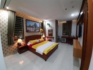 1 dormitorio con 1 cama y TV en Hotel Phú Sĩ, en Ho Chi Minh