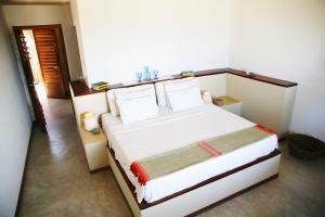 a bedroom with a bed with white sheets and pillows at maison au zenit in Maceio +23 photos