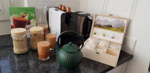 a counter with a coffee maker and other items on it at like home in Rüti