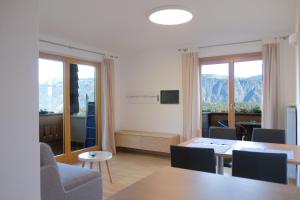 a living room with a table and chairs and mountains at Tirolerhof Tisens in Tesimo