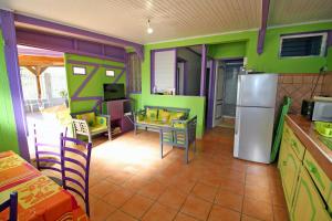 - une cuisine avec des murs verts et violets et un réfrigérateur dans l'établissement CHEZ JOJO, à Sainte-Anne