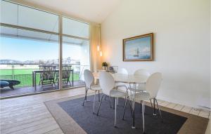 ein Esszimmer mit einem Tisch und Stühlen sowie einem Balkon in der Unterkunft Gorgeous Apartment In Ebeltoft With Sauna in Ebeltoft